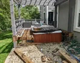Hot tub being demolished and removed from a deck